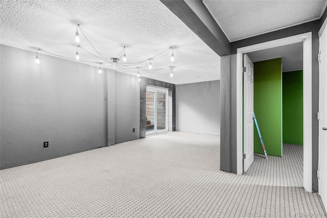 unfurnished room featuring a textured ceiling, carpet, and rail lighting