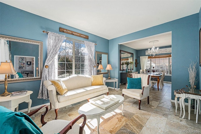 5224 Snow Goose St, Brighton, CO 80601 - living area featuring baseboards, a wealth of natural light, and an inviting chandelier