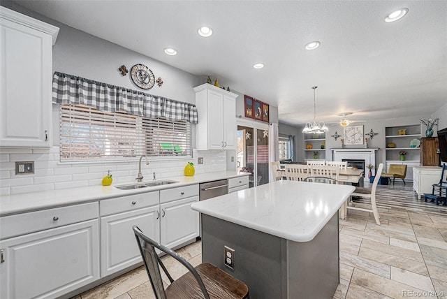 5224 Snow Goose St, Brighton, CO 80601 - kitchen featuring a kitchen island, open floor plan, light countertops, white cabinetry, and a sink