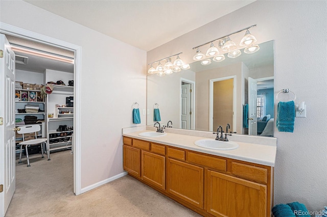 5224 Snow Goose St, Brighton, CO 80601 - bathroom featuring a sink, a spacious closet, baseboards, and double vanity