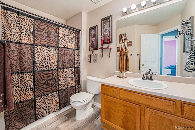 5224 Snow Goose St, Brighton, CO 80601 - bathroom featuring visible vents, a shower with shower curtain, toilet, vanity, and wood finished floors