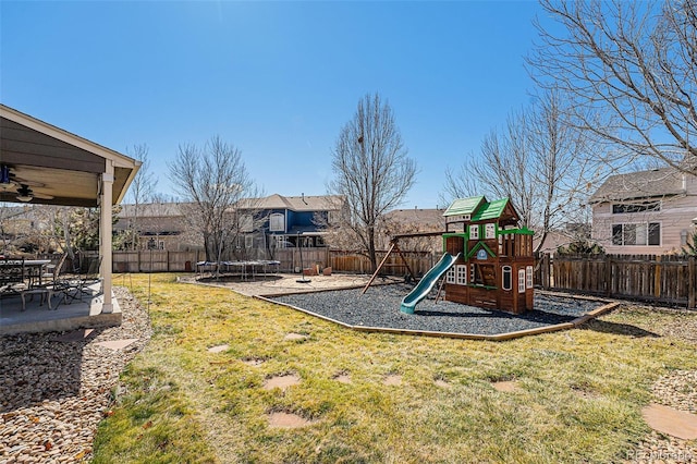 5224 Snow Goose St, Brighton, CO 80601 - communal playground featuring a trampoline, a patio area, a fenced backyard, and a lawn