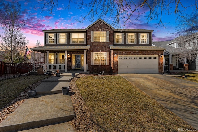 traditional-style house with covered porch, brick siding, driveway, and fence