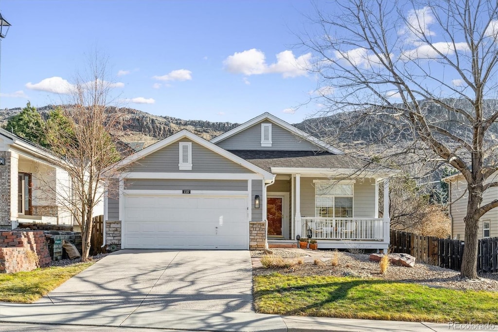 view of front of home featuring covered porch, a mountain view, and a garage