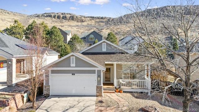 view of front facade featuring covered porch, a mountain view, and a garage