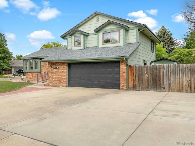 1460 Belmont Dr, Longmont, CO 80503 - view of front of home featuring a garage, brick siding, a shingled roof, and concrete driveway