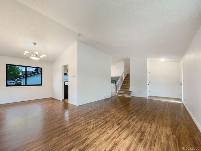 1460 Belmont Dr, Longmont, CO 80503 - unfurnished living room with a chandelier, wood finished floors, lofted ceiling, stairs, and a textured ceiling