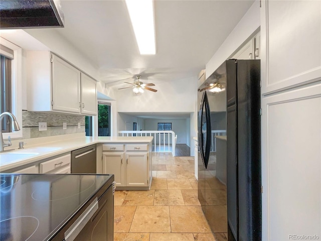 1460 Belmont Dr, Longmont, CO 80503 - kitchen featuring freestanding refrigerator, stainless steel dishwasher, ceiling fan, a peninsula, and white cabinetry