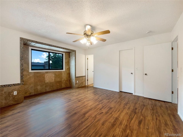 1460 Belmont Dr, Longmont, CO 80503 - unfurnished bedroom with wood finished floors, a textured ceiling, a ceiling fan, and wainscoting