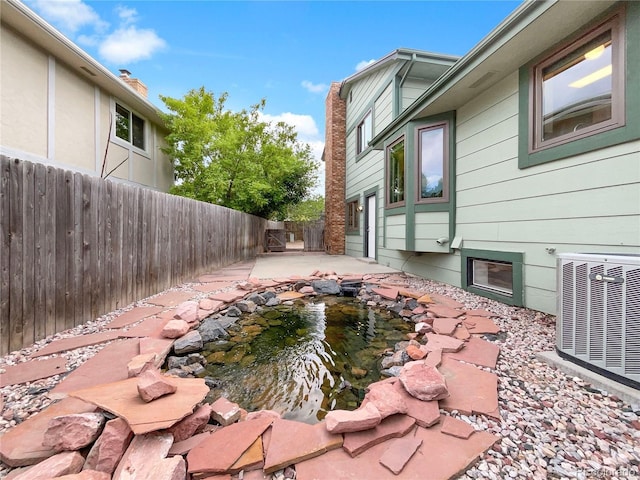 1460 Belmont Dr, Longmont, CO 80503 - fenced backyard featuring a small pond and a patio area