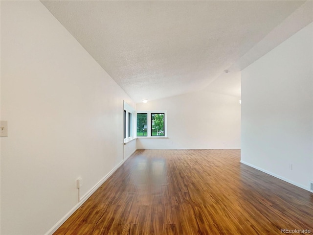 1460 Belmont Dr, Longmont, CO 80503 - empty room with wood finished floors, lofted ceiling, and a textured ceiling