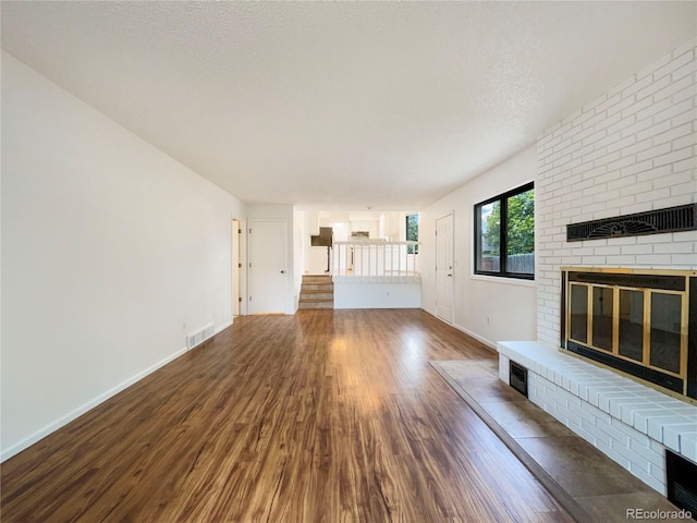 1460 Belmont Dr, Longmont, CO 80503 - unfurnished living room featuring a fireplace, wood finished floors, and stairs