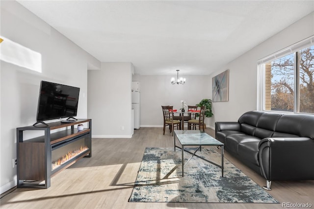 living room featuring an inviting chandelier and light hardwood / wood-style flooring