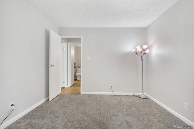 carpeted empty room with a textured ceiling