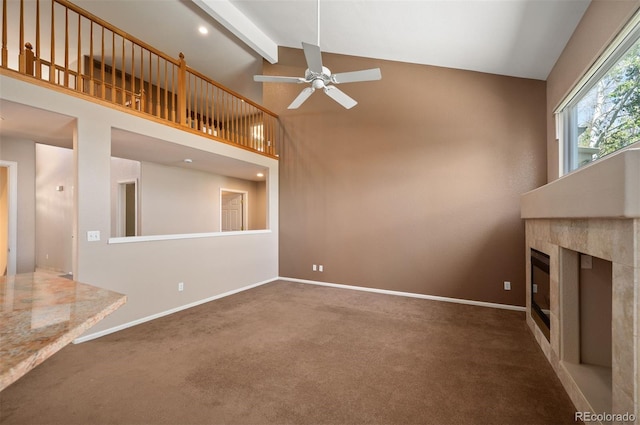 15577 Greenstone Cir, Parker, CO 80134 - unfurnished living room featuring a ceiling fan, carpet flooring, beamed ceiling, high vaulted ceiling, and a tiled fireplace