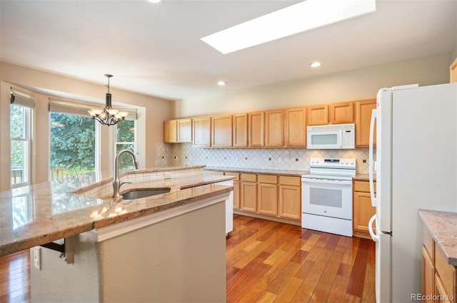 15577 Greenstone Cir, Parker, CO 80134 - kitchen featuring white appliances, light wood-style floors, light brown cabinetry, backsplash, and light stone counters
