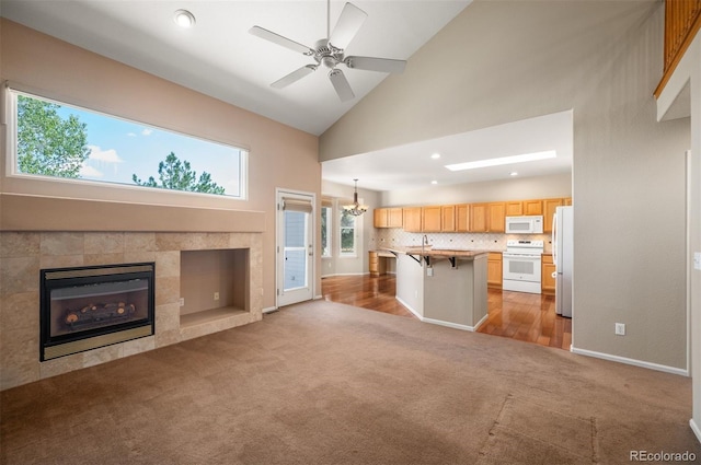 15577 Greenstone Cir, Parker, CO 80134 - unfurnished living room featuring carpet, high vaulted ceiling, a fireplace, a ceiling fan, and recessed lighting