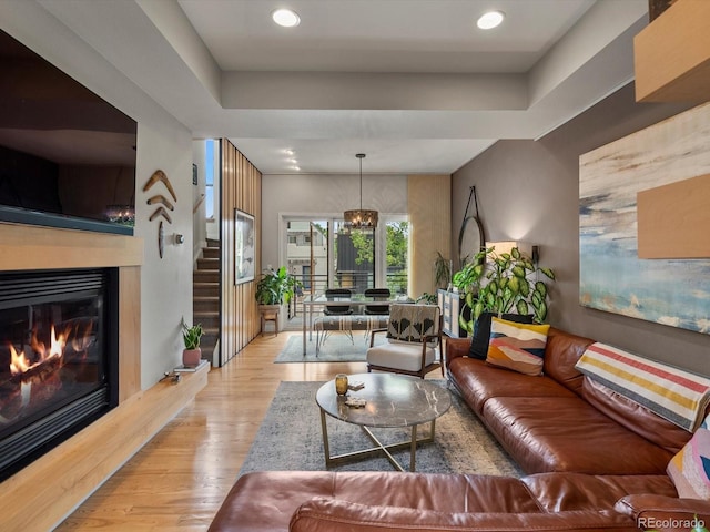1880 W 32nd Ave, Denver, CO 80211 - living area with light wood-type flooring, a glass covered fireplace, a raised ceiling, a chandelier, and recessed lighting