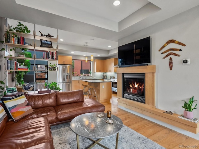1880 W 32nd Ave, Denver, CO 80211 - living room with light wood-style flooring, a glass covered fireplace, a tray ceiling, and recessed lighting
