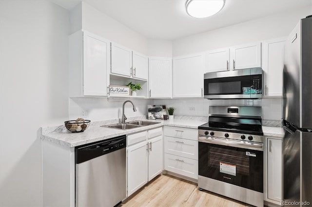 660 S Alton Way Unit 12C, Denver, CO 80247 - kitchen featuring appliances with stainless steel finishes, white cabinets, open shelves, light wood-type flooring, and backsplash