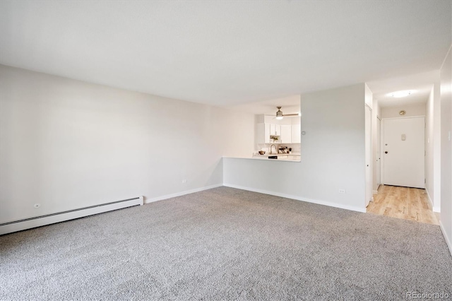 660 S Alton Way Unit 12C, Denver, CO 80247 - unfurnished living room featuring light carpet and a baseboard radiator