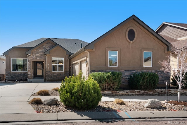 6203 Adamants Dr, Colorado Springs, CO 80924 - view of front of house featuring an attached garage, stone siding, and stucco siding