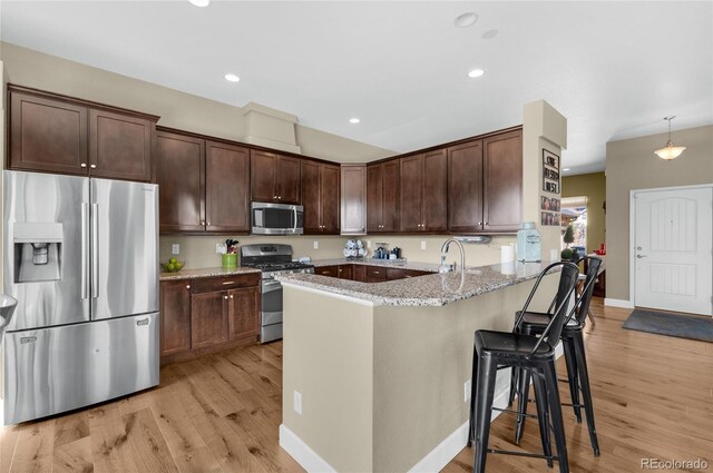 6203 Adamants Dr, Colorado Springs, CO 80924 - kitchen featuring stainless steel appliances, a peninsula, dark brown cabinets, and light stone counters