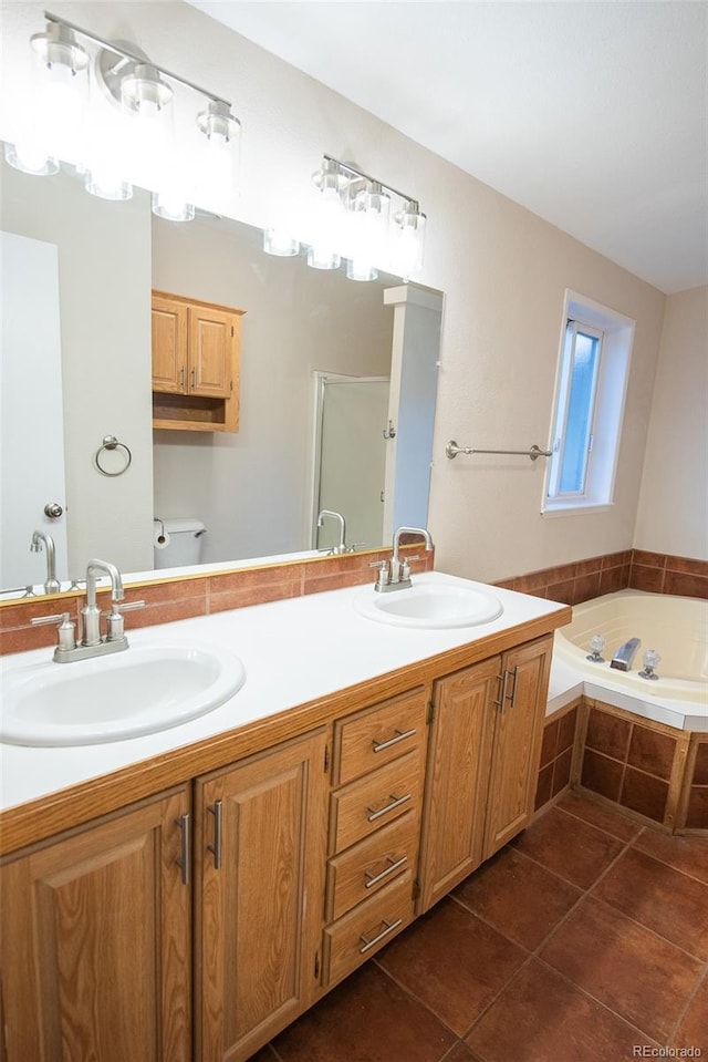 full bathroom featuring tile patterned floors, double vanity, a sink, and a bath