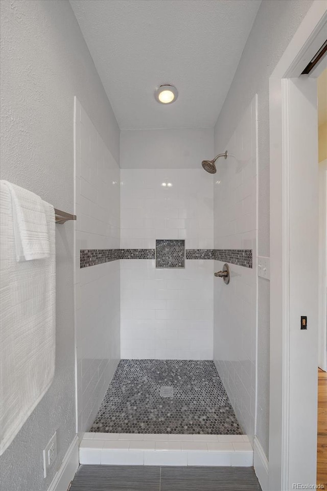 3764 Newton St, Denver, CO 80211 - bathroom featuring tiled shower and wood finished floors