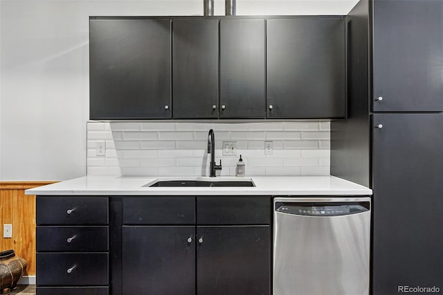 kitchen with dishwasher, a sink, backsplash, and dark cabinetry