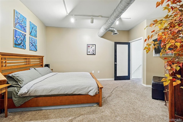 bedroom with rail lighting, carpet, baseboards, and attic access