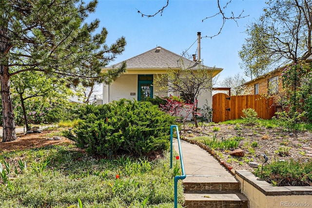 bungalow-style house with brick siding, a gate, fence, and a shingled roof