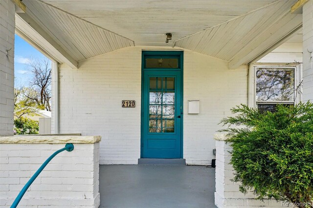 doorway to property with brick siding