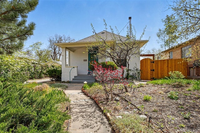 bungalow with brick siding, a gate, and fence