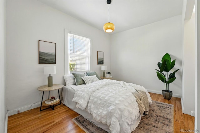 bedroom with baseboards and light wood-style flooring