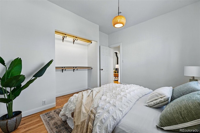 bedroom featuring baseboards and wood finished floors