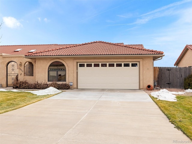 mediterranean / spanish-style house featuring a garage and a front lawn