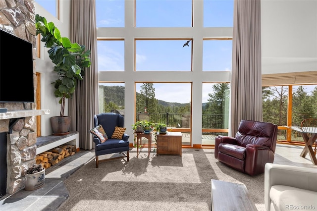 729 Sawmill Rd, Loveland, CO 80537 - carpeted living room featuring a towering ceiling and a stone fireplace