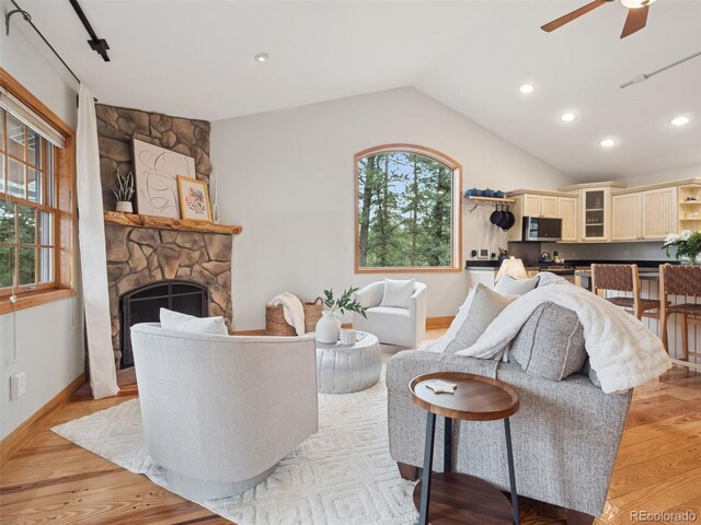27905 Mariposa Rd, Evergreen, CO 80439 - living room with light wood finished floors, a fireplace, a ceiling fan, recessed lighting, and lofted ceiling