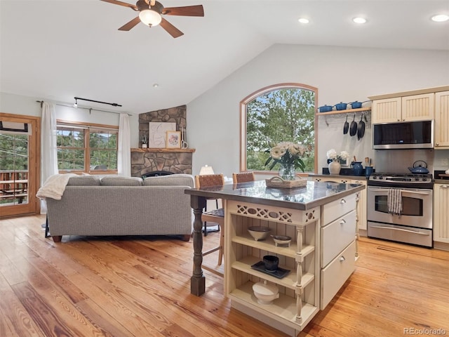 27905 Mariposa Rd, Evergreen, CO 80439 - kitchen featuring ceiling fan, cream cabinets, open shelves, vaulted ceiling, and stainless steel appliances