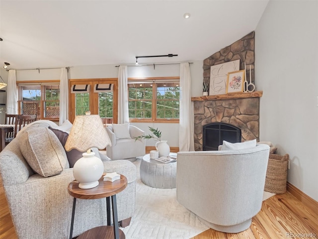 27905 Mariposa Rd, Evergreen, CO 80439 - living room featuring a stone fireplace, baseboards, and wood finished floors