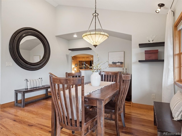 27905 Mariposa Rd, Evergreen, CO 80439 - dining room with baseboards, arched walkways, light wood-style flooring, and lofted ceiling