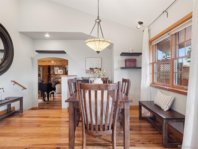 27905 Mariposa Rd, Evergreen, CO 80439 - dining area with arched walkways, light wood finished floors, and lofted ceiling