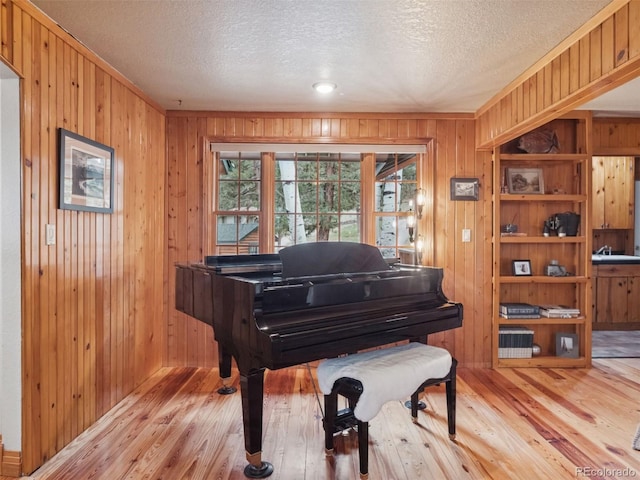 27905 Mariposa Rd, Evergreen, CO 80439 - sitting room featuring wooden walls, a textured ceiling, and light wood-style floors
