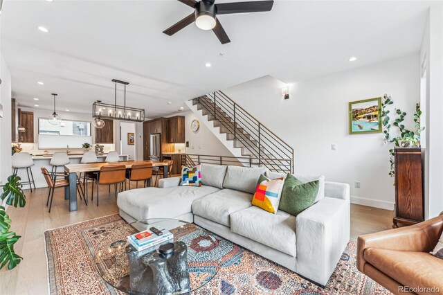 living room featuring ceiling fan and light hardwood / wood-style flooring