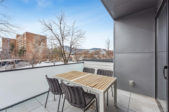 snow covered back of property featuring a mountain view