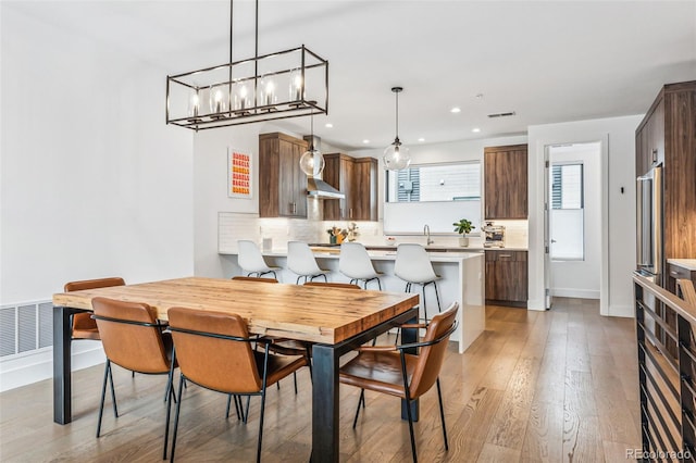 dining room featuring sink and light hardwood / wood-style floors