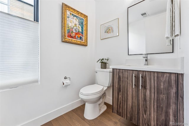 bathroom with wood-type flooring, vanity, and toilet