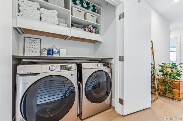 laundry area with washer and clothes dryer and light hardwood / wood-style flooring