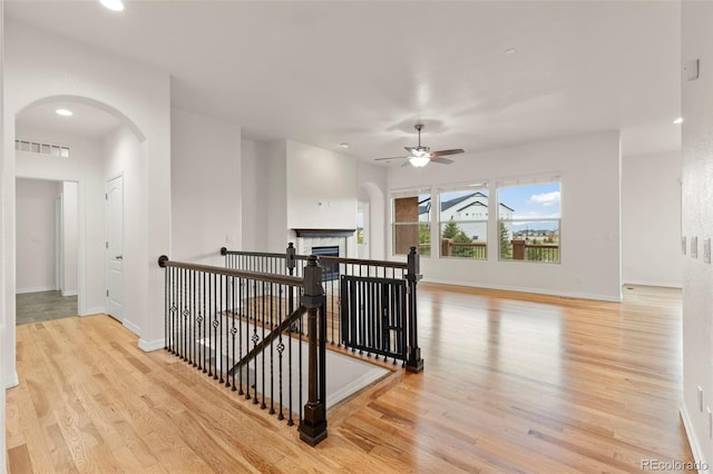 2423 Delicato Ct, Colorado Springs, CO 80921 - hall with wood finished floors, an upstairs landing, arched walkways, baseboards, and recessed lighting